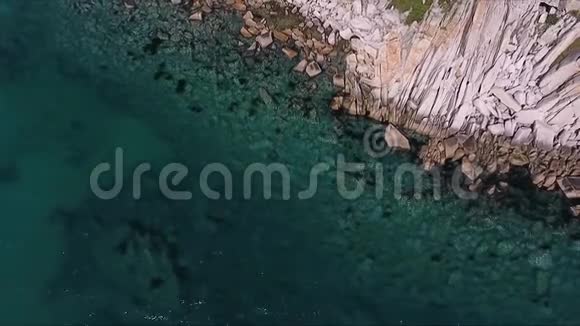 高空拍摄山崖和蓝色海水岩石悬崖和海水在海湾空中景观从上面视频的预览图