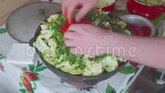 白色厨师的手把西红柿放在切好的蔬菜上放在大锅里里面有蔬菜视频的预览图