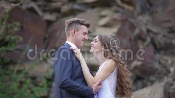 新娘和新郎拥抱在山上的背景下举行婚礼视频的预览图