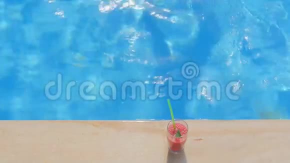 戴着夏帽的女人在泳池边喝鸡尾酒俯瞰美景视频的预览图