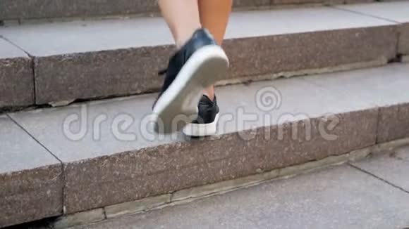 特写慢动作视频穿着黑色运动鞋的时髦年轻女子走上楼梯视频的预览图