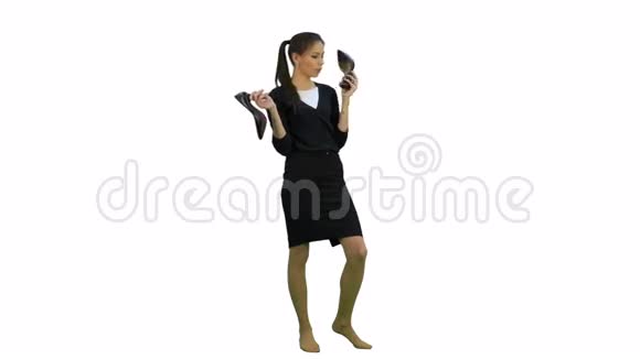年轻健谈的女人在白色背景下用鞋子就像电话视频的预览图