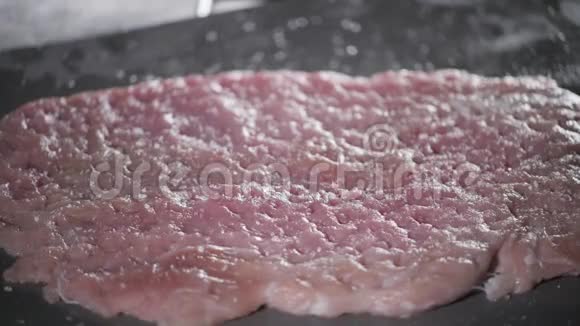 把盐放进去维纳施尼泽尔生猪肉准备用油腌料在煎锅里用火煮专业人员视频的预览图