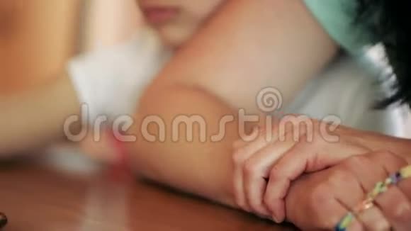 小女孩坐在咖啡馆里和她的母亲一起悲伤做梦他用手拥抱妈妈特写视频的预览图