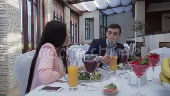 一对恋爱中的情侣在餐馆吃饭时谈股票录像视频的预览图