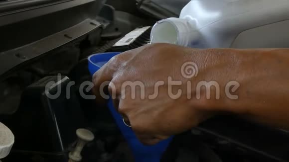 机械手特写镜头向汽车发动机灌注发动机润滑油视频的预览图