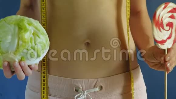 腹部平坦的女人蓝色背景的特写健康食品健身视频的预览图