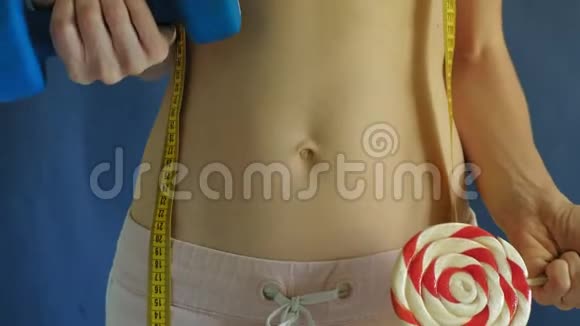 腹部平坦的女人蓝色背景的特写健康食品健身视频的预览图