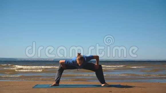 肌肉发达的年轻人锻炼身体瑜伽女神相扑选手的姿势视频的预览图