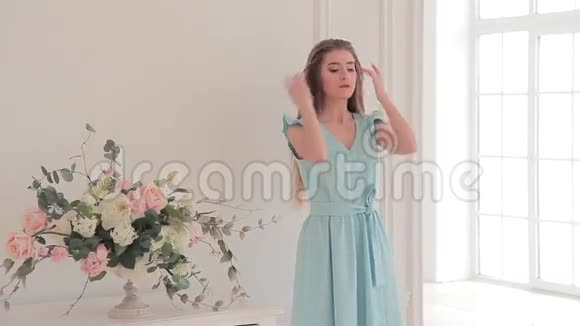 漂亮的年轻模特穿着淡蓝色连衣裙摆着目录照片视频的预览图