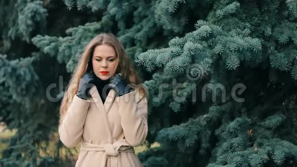 像妮可基德曼的女人穿着松树慢动作在冬季公园视频的预览图