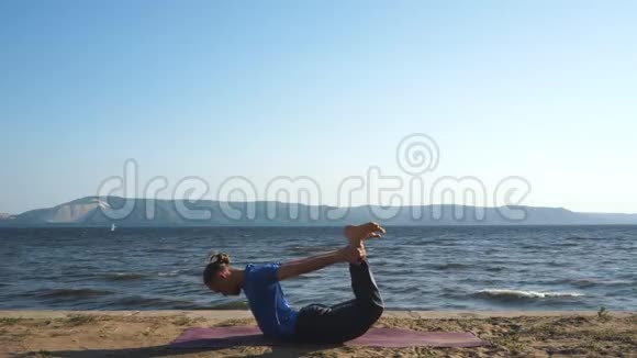 运动青年做瑜伽练习坐前弯姿势视频的预览图