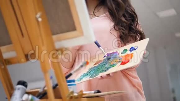 女孩拿着画笔为她的照片混合颜色视频的预览图