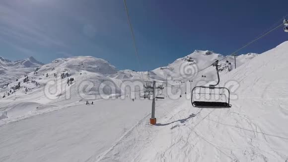从椅子上抬升到冬季滑雪场山顶的镜头视频的预览图
