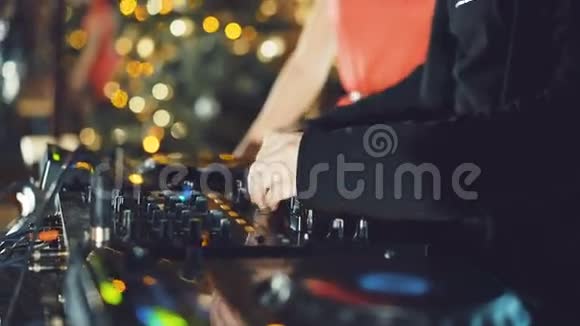 DJ手在4K中调整DJ甲板上的各种轨道控制装置视频的预览图