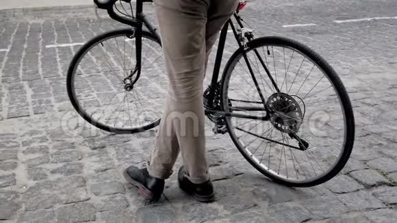 慢镜头的时尚年轻人站在老路上骑自行车视频的预览图