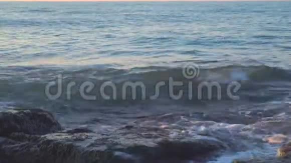 波浪溅落在长满绿藻的岩石上视频的预览图