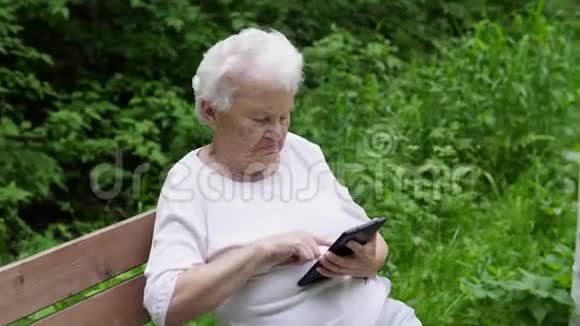 老奶奶看着互联网智能手机视频的预览图
