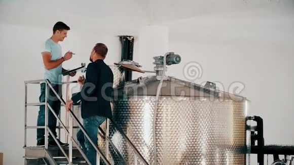 商人酿酒师和控制酿酒厂生产葡萄酒的技术人员视频的预览图