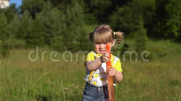 快乐的孩子在夏天的公园里吹肥皂泡慢动作视频的预览图
