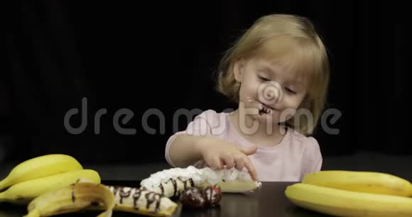 孩子们吃香蕉草莓融化的巧克力和鲜奶油视频的预览图