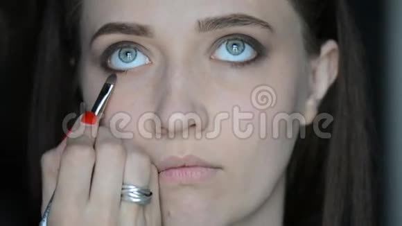 化妆师用化妆设备在模特的眼睛和眉毛上化妆眼部睫毛膏化妆视频的预览图
