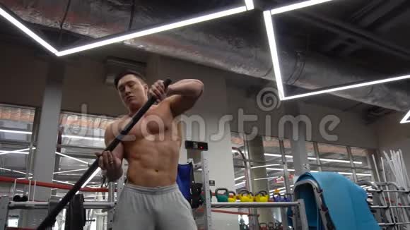 强壮的肌肉男用大锤敲打轮胎作为他健身健身体操训练的一部分视频的预览图