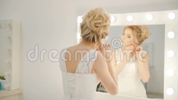 一个漂亮女孩戴上耳环的镜子里的倒影视频的预览图