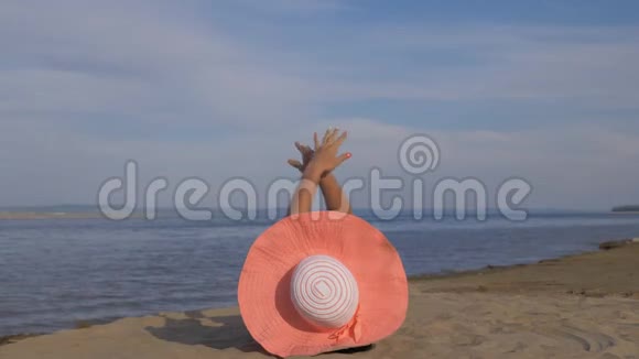 美丽的女人躺在海滩上做热身腿视频的预览图