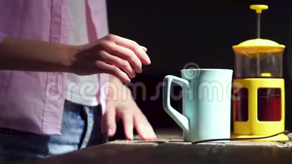 年轻的女人在白色的杯子里倒茶视频的预览图