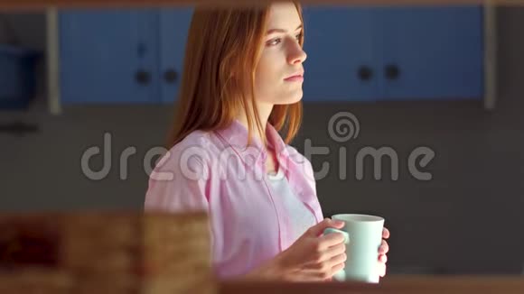 年轻漂亮的女人喝茶站在窗边做梦视频的预览图