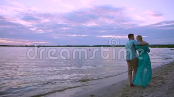 情侣牵手在海滩日落蜜月度假旅游快乐浪漫的年轻情人男人和女人视频的预览图