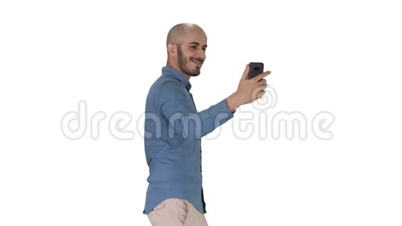 快乐微笑英俊的年轻人在白色背景上行走时自拍视频的预览图