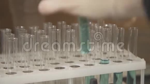 塑料三脚架中带有有色液体化学物质的试管视频的预览图