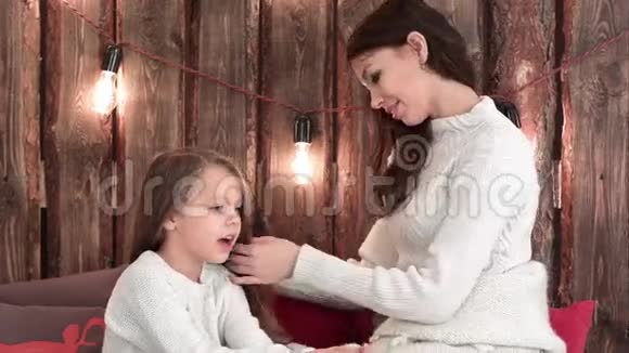 快乐的母亲在她唱圣诞歌时女儿梳头视频的预览图