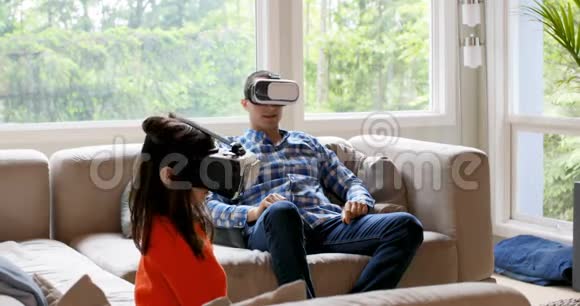 父亲和女儿使用虚拟现实耳机4k视频的预览图
