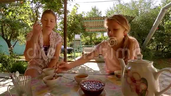 两个姐妹在阳光明媚的午后在克里米亚鞑靼人的房子里吃果酱视频的预览图