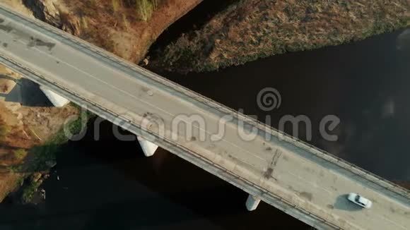横跨河流的桥上汽车交通的高空俯视图视频的预览图