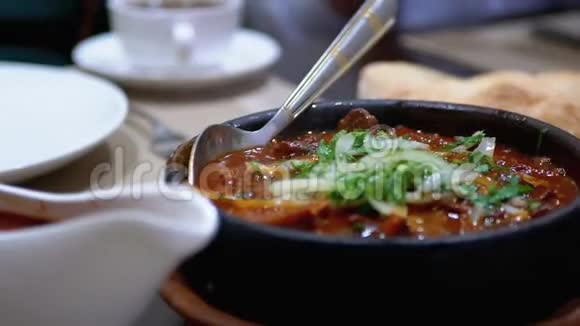餐厅Ketsi的格鲁吉亚肉盘查舒舒利桌子上的泥锅里的热肉视频的预览图