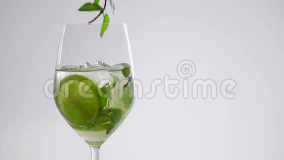 一枝薄荷落在玻璃杯里的鸡尾酒上视频的预览图