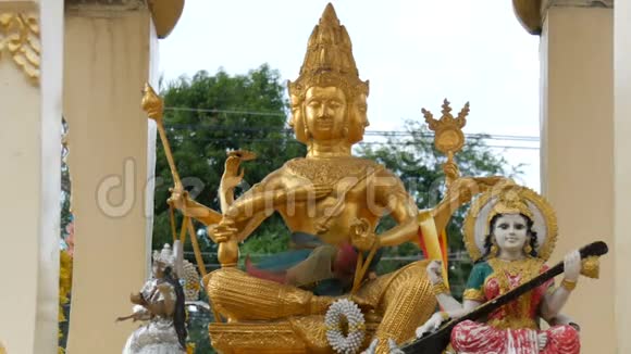 在花园里的一个供祈祷的金色佛教小祭坛上面装饰着鲜花和各种雕像视频的预览图