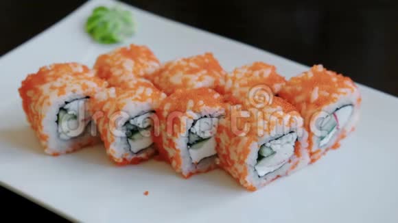 在一个白色的长方形盘子里放上鱼子酱腌姜和芥末卷视频的预览图