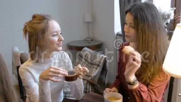 年轻漂亮的女孩喝茶喝咖啡有趣交流视频的预览图