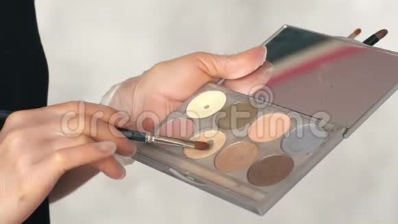 化妆师在美容院使用眼影调色板视频的预览图
