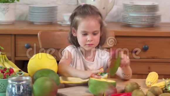 漂亮的小女孩正在吃一个多汁的黄瓜视频的预览图