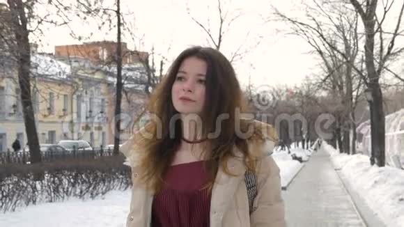 年轻漂亮的女孩走过城市的街道慢动作视频的预览图