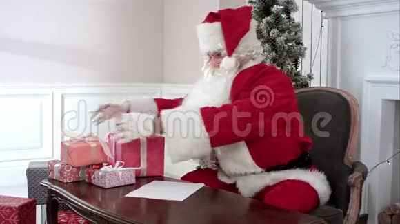 圣诞老人在孩子们的愿望清单上检查礼物做笔记视频的预览图
