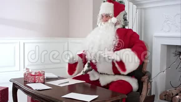 圣诞老人忙着孩子们的信件而圣诞老人的小帮手们带来更多的礼物视频的预览图