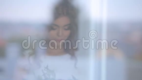 窗玻璃上映着一个美丽性感女孩的肖像神秘的形象视频的预览图
