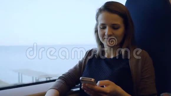 年轻女孩用手机上网坐火车旅行视频的预览图